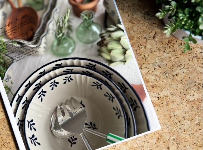 På denna bild kan man se en tidning som ligger på ett bord. I tidningen visas en bild från oss på Miljögården, en bild från Beddingestrand där vi har ställt upp några av våra utemöbler. Det står en krukväxt på bordet också. På bilden står det 